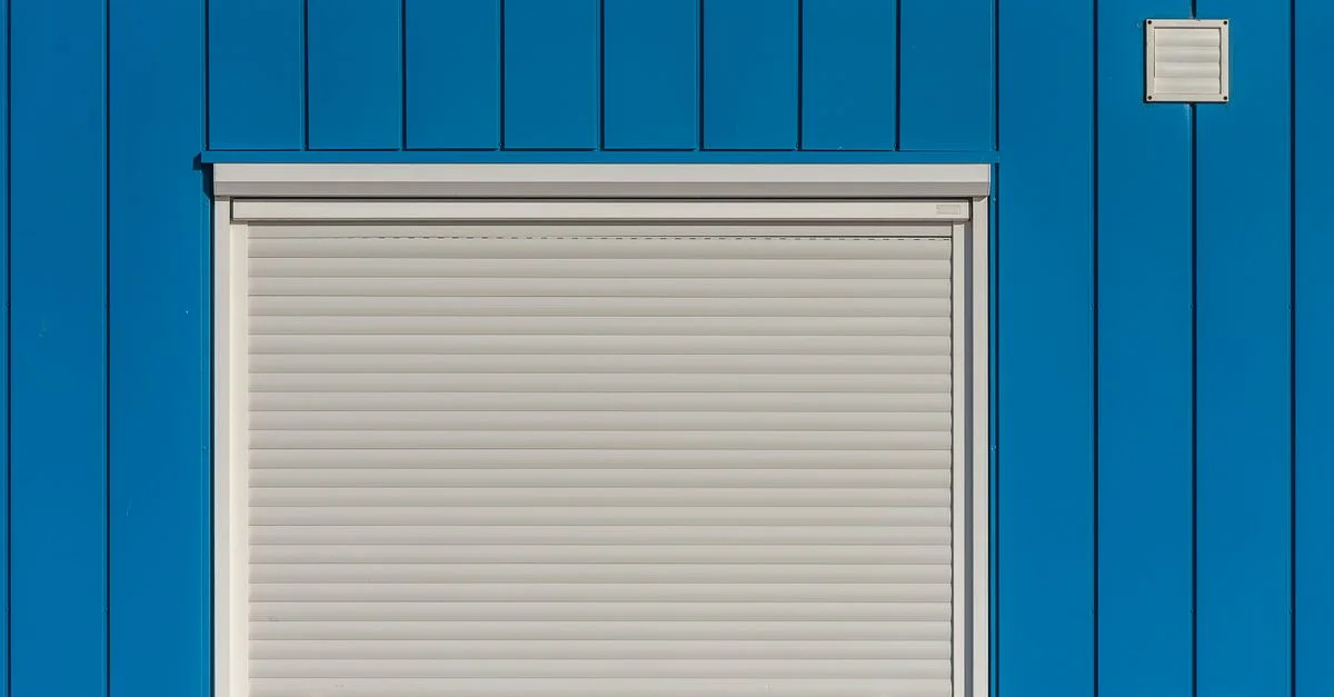 Un mur bleu moderne avec un rideau roulant blanc fermé, parfait pour des designs architecturaux.