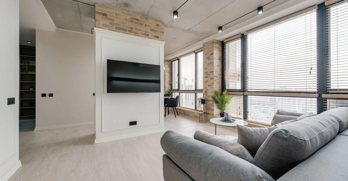 Salon moderne lumineux avec un décor élégant et de grandes fenêtres.