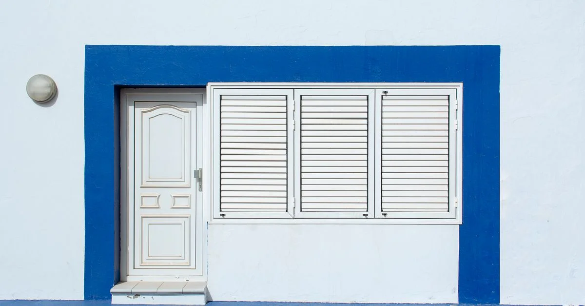 Façade de maison blanche et bleue avec porte et volets à Lanzarote, Espagne.